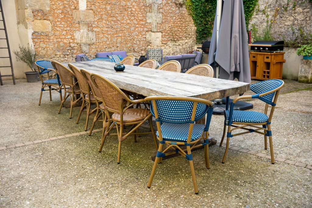 Grande table extérieure du Patio Bleu près d’Aubeterre en Charente, partagée entre le gîte et la maison d’hôtes, idéale pour des repas conviviaux en plein air